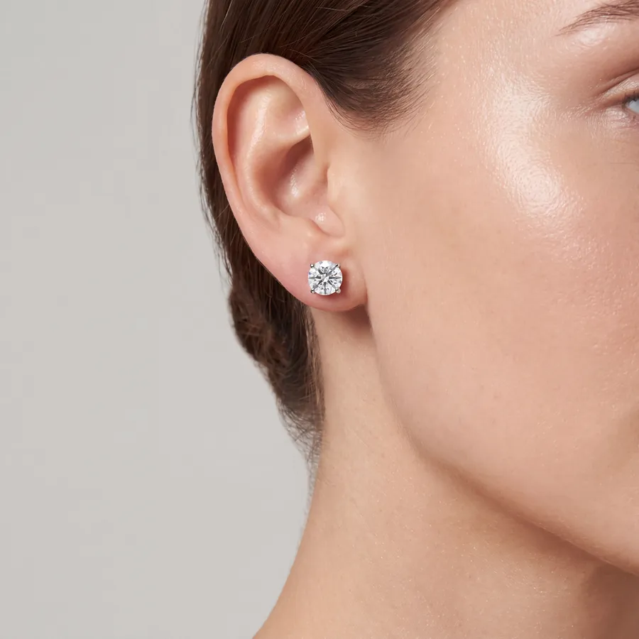 Solitaire diamond stud earring in white gold worn on the ear